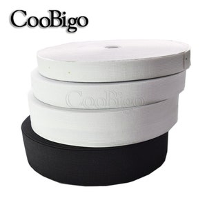 May include: A stack of white and black elastic bands. The white elastic bands are stacked on top of each other, and the black elastic band is on the bottom.