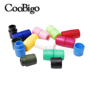 May include: Assortment of colourful plastic cord stoppers. The stoppers are in various colours, including red, blue, green, yellow, white, black, and pink.