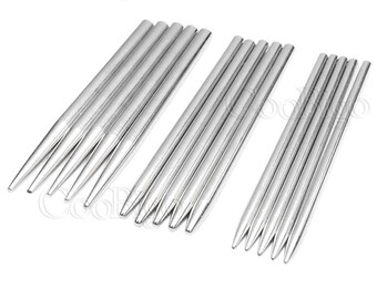 May include: A set of 18 silver metal knitting needles. The needles are arranged in three groups of six. The needles are sharp and pointed.