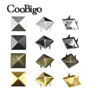 Può includere: Assortimento di borchie metalliche quadrate e piramidali in argento, nero, bronzo e oro. Le borchie hanno una base piatta con perni per il fissaggio. Il marchio "CooBigo" è visualizzato in alto.