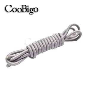May include: A coiled length of gray elastic shoelaces. The shoelaces are made of a woven material and are designed to be used in place of traditional shoelaces.