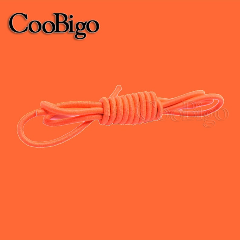 Peut inclure: Lacets &eacute;lastiques orange, un type de lacet sans n&oelig;ud, enroul&eacute;s sur un fond orange vif.