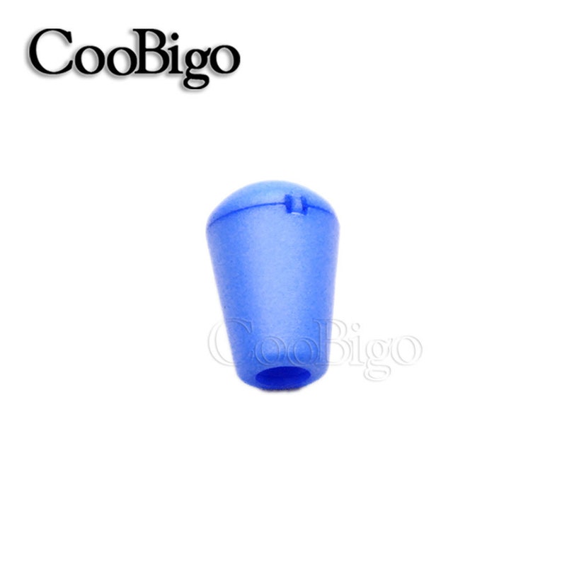 May include: A blue plastic cord end stop with a rounded top and a hole in the center.
