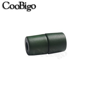 May include: A dark green plastic toggle clasp for jewellery making. The clasp is made of two pieces that snap together.