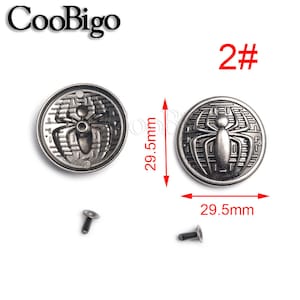 May include: Two silver-toned metal buttons with a spider design. Each button measures 29.5 mm in diameter. The buttons are accompanied by two silver-toned metal rivets.