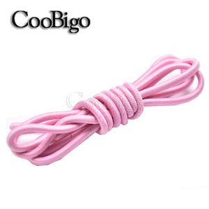 May include: Pink elastic shoelace, a type of round elastic cord, is coiled on a white background.