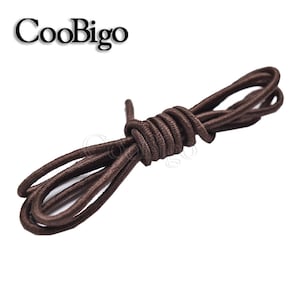 May include: Brown elastic shoelaces, a type of no-tie shoelace, are coiled together on a white background.