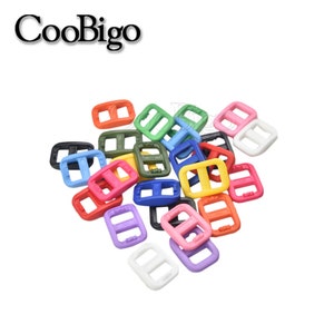 May include: A pile of colorful plastic buckle sliders in various colors, including red, orange, yellow, green, blue, purple, pink, and white.