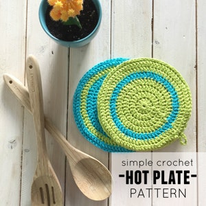 May include: Two crocheted green and blue hot pads on a white wooden surface. The text "simple crochet -HOT PLATE- PATTERN" is below the hot pads.