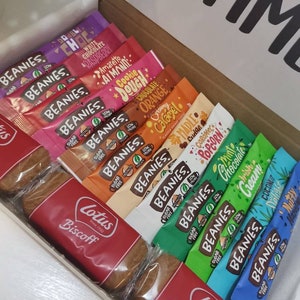May include: A gift box filled with a variety of individually wrapped sugar-free beanies in flavors like cookie dough, creamy orange, and maple fudge. The box also includes two Lotus Biscoff cookies.