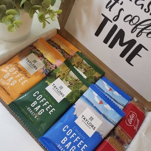 May include: A gift box filled with coffee bags and biscuits. The coffee bags are from Taylors of Harrogate and come in a variety of flavors, including Flying Start, Rich Italian, and Decaff&eacute;. The biscuits are Lotus Biscoff.