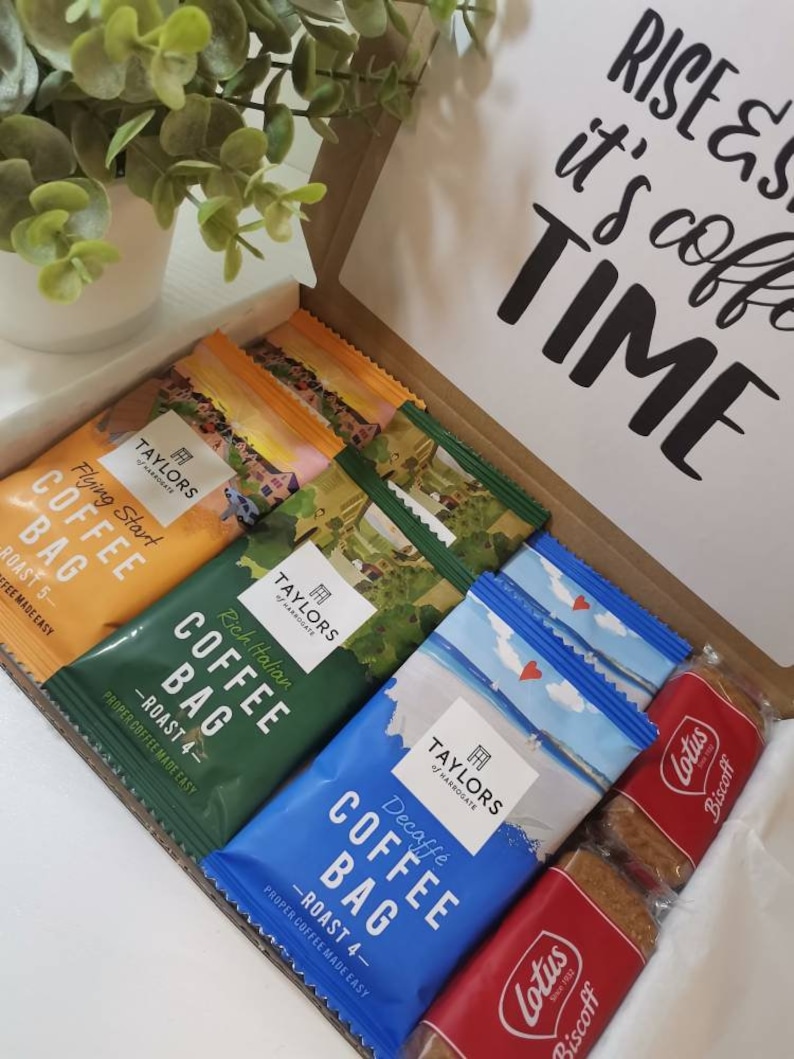 May include: A gift box filled with coffee bags and biscuits. The coffee bags are from Taylors of Harrogate and come in a variety of flavors, including Flying Start, Rich Italian, and Decaff&eacute;. The biscuits are Lotus Biscoff.