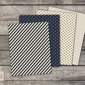 May include: Four sheets of decorative paper with nautical themes. The papers feature a diagonal stripe pattern, anchors, a wheel pattern, and a wavy line pattern. All of the patterns are in navy blue on a cream background.