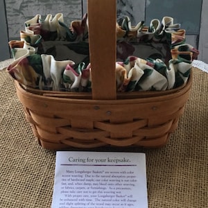 May include: A brown woven Longaberger basket with a floral fabric liner. The basket has a wooden handle and is labeled "1995 Horizon of Hope Basket 17124". The label also includes care instructions for the basket.