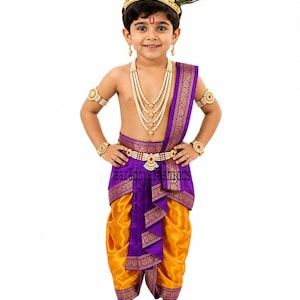 May include: A traditional costume featuring a bright yellow dhoti with a purple border and a matching purple sash. The outfit includes a gold-toned crown with a peacock feather, layered pearl necklaces, armlets, and a waist belt with red accents.