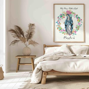 May include: A white framed print with a watercolor illustration of the Virgin Mary in a blue robe surrounded by a wreath of flowers. The text "Holy Mary Mother of God" and "Pray for us" is printed below the image.