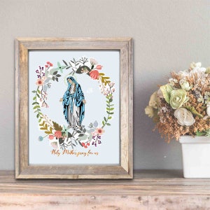 May include: A framed print of the Virgin Mary surrounded by a floral wreath. The print has a light blue background and the text "Holy Mother pray for us" at the bottom.