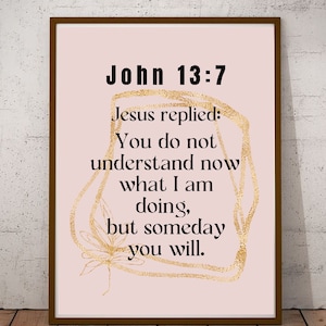 May include: Framed print with the text "John 13:7" and a quote from Jesus on a pink background. The text is in black, with gold decorative accents. The frame is brown, and the print is displayed on a wooden surface.