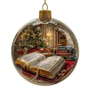 May include: A clear glass Christmas ornament with a detailed interior scene. Inside, a decorated Christmas tree, open book, and stacks of books are visible. The ornament has a gold-colored metal cap and a festive, detailed design.