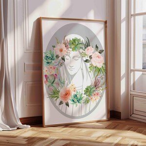 May include: A watercolor painting of a woman's face with a floral crown of pink and white flowers and green succulents. The background is a light gray oval.