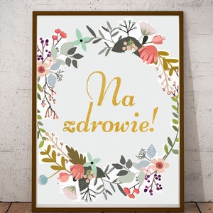 Puede incluir: Una impresión enmarcada con un diseño de corona floral en tonos de rosa, verde y morado. La corona rodea el texto "Na zdrowie!" en letras doradas.