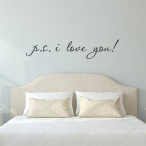May include: A white bed with a headboard and two nightstands. The wall behind the bed has a black cursive inscription that reads "P.S. I love you!"