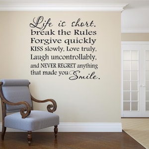 Könnte beinhalten: Ein schwarzer Wandaufkleber mit dem Text: Life is short. break the Rules Forgive quickly KISS slowly, Love truly, Laugh uncontrollably, and NEVER REGRET anything that made you Smile. Die Schrift ist auf einer hellbeigen Wand angebracht.