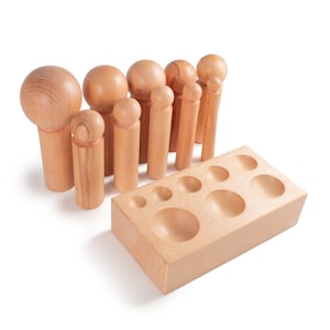 May include: A set of wooden leather craft tools with a variety of sizes and shapes. The tools are made of natural wood and have a smooth finish. The set includes a wooden block with different sized holes for creating leather punches.