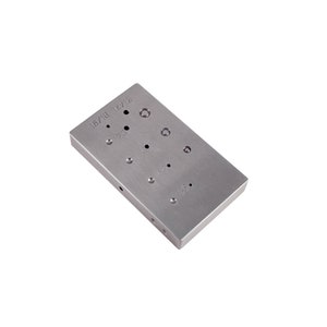 May include: A silver metal plate with a variety of circular holes of different sizes. The plate is labeled with various sizes, including 18/18, 14/12, 12/3, 11/3, 10/3, 9/3, 8/3, 7/3, 6/3, 5/3, 4/3, 3/3, 2/3, and 1/3.