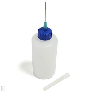 May include: A white plastic bottle with a blue cap and a thin needle attached. The bottle is used for dispensing liquids. A separate clear plastic tube is included.