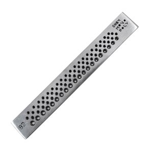 May include: A silver metal tool with a series of holes of varying sizes. The tool is labeled "SHEM POLY" and "82".