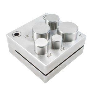 May include: A metal punch set with six different sized circular punches. The punches are labeled with their sizes: 1", 7/8", 1/2", 5/8", and two unlabeled punches.