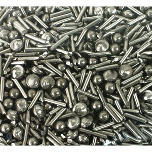 May include: A close-up image of a pile of silver-coloured metal shot. The shot is a mix of small spheres and short cylinders.