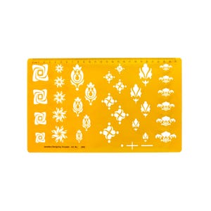 May include: Yellow plastic jewelry design template with a ruler and various white design stencils. The template includes a variety of floral and geometric patterns.