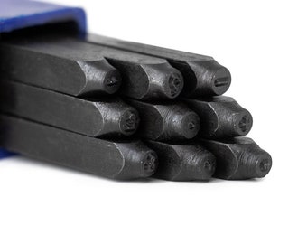 May include: A set of black metal letter stamps in a blue case. The stamps are arranged in a stack, with the letters facing outward. The letters are in a variety of fonts and sizes.
