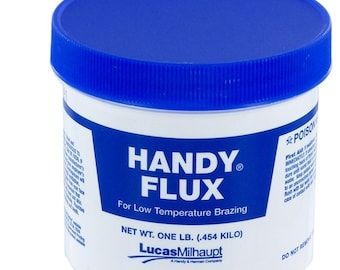 Op de afbeelding: Een witte plastic container met een blauwe deksel, met het opschrift "HANDY FLUX" voor solderen bij lage temperatuur. Het nettogewicht is 0,454 kilo. De merknaam "Lucas-Milhaupt" is ook zichtbaar.