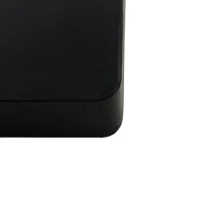 May include: A black square-shaped hard drive with rounded edges.