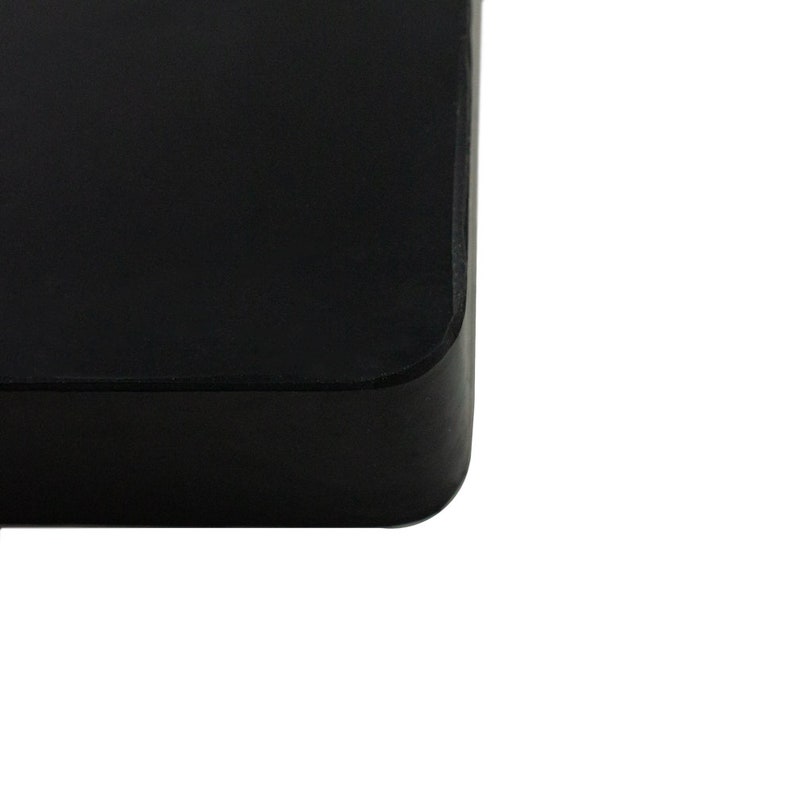 May include: A black square-shaped hard drive with rounded edges.