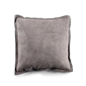 May include: A gray suede pillow with a stitched border.