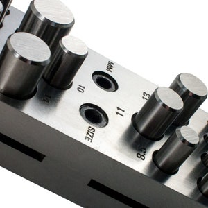 May include: A metal tool with a series of round punches of different sizes. The tool is labeled "SIZE" and has numbers 8.5, 10, 11, 13, and 14.
