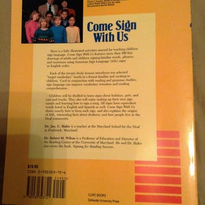 May include: A yellow and orange book cover with the title "Come Sign With Us". The book cover features a group of children and adults signing in American Sign Language (ASL). The book is a fully illustrated activities manual for teaching children sign language. The book cover also includes the ISBN number, price, and author information.