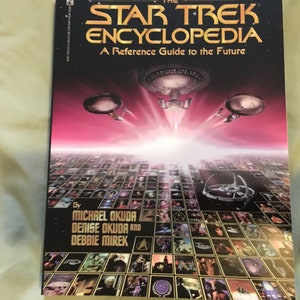 May include: The cover of "Star Trek Encyclopedia: A Reference Guide to the Future" by Michael Okuda, Denise Okuda, and Debbie Mirek. The cover features a red and pink background with a bright white light in the center. Three starships are flying towards the light. The bottom of the cover features a grid of small images.