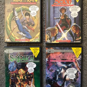 May include: Four DVD cases from the Digital Comic Book Series. Titles include "Way of the Rat," "Scion," "Sojourn," and "Negation." Each case features colorful comic book art and text, with the PlayStation 2, Xbox, and PC compatibility information.