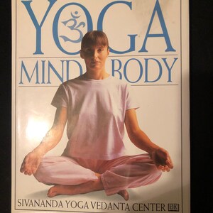 May include: A book titled "Yoga Mind Body" with a woman sitting in a yoga pose on the cover. The book is published by the Sivananda Yoga Vedanta Center.
