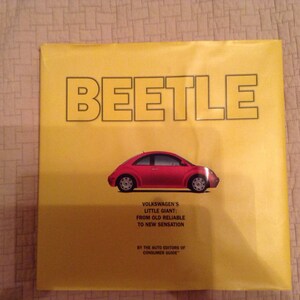 May include: A yellow book cover with the title "BEETLE" in black letters. A red Volkswagen Beetle is pictured on the cover. The text below the car reads "Volkswagen's Little Giant: From Old Reliable to New Sensation." The text at the bottom of the cover reads "By the Auto Editors of Consumer Guide."