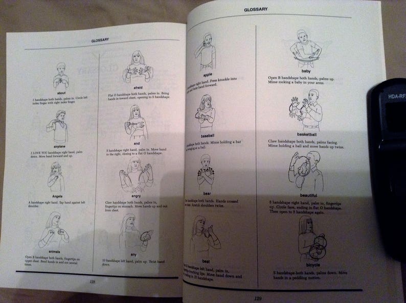 May include: A black and white illustrated glossary of American Sign Language (ASL) signs. The signs are organized in alphabetical order and include the sign for "airplane", "angel", "baby", "bear", "beautiful", "bike", "bird", and more.