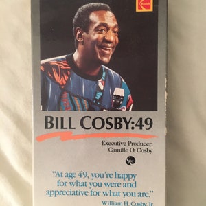 Pode incluir: Uma fita VHS com Bill Cosby com o título "BILL COSBY:49" e o texto "At age 49, you're happy for what you were and appreciative for what you are."  Produtor executivo: Camille O. Cosby.
