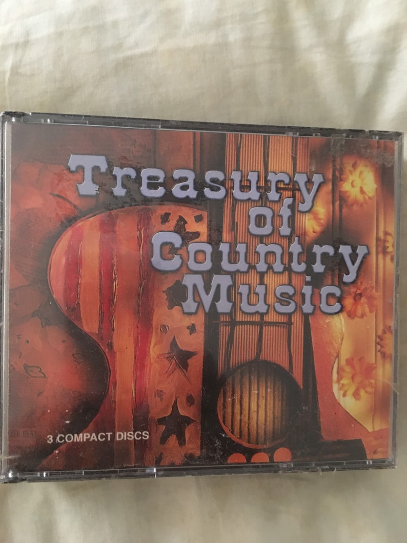 May include: A 3-disc CD set titled "Treasury of Country Music". The cover features a stylized image of a guitar with an American flag design and stars.