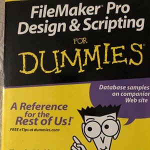 May include: A yellow and black book titled "FileMaker Pro Design & Scripting For Dummies." The book cover features the text "A Reference for the Rest of Us!" and a cartoon illustration of a person pointing.