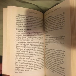 Puede incluir: Primer plano de una p&aacute;gina de libro con el t&iacute;tulo "Espondilolistesis" y una descripci&oacute;n de la condici&oacute;n. El texto trata sobre la causa, los s&iacute;ntomas y el tratamiento de esta condici&oacute;n, que afecta las v&eacute;rtebras de la columna vertebral.